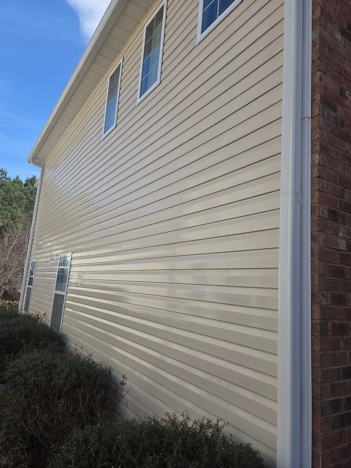 Same two-story vinyl siding house after soft washing, clean and streak-free